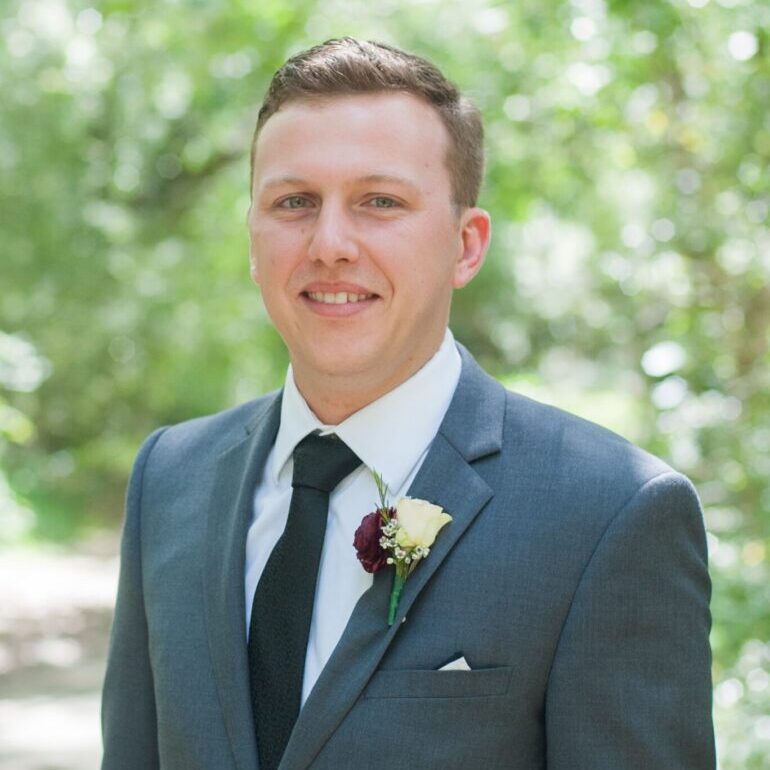 Smiling man in gray suit outdoors