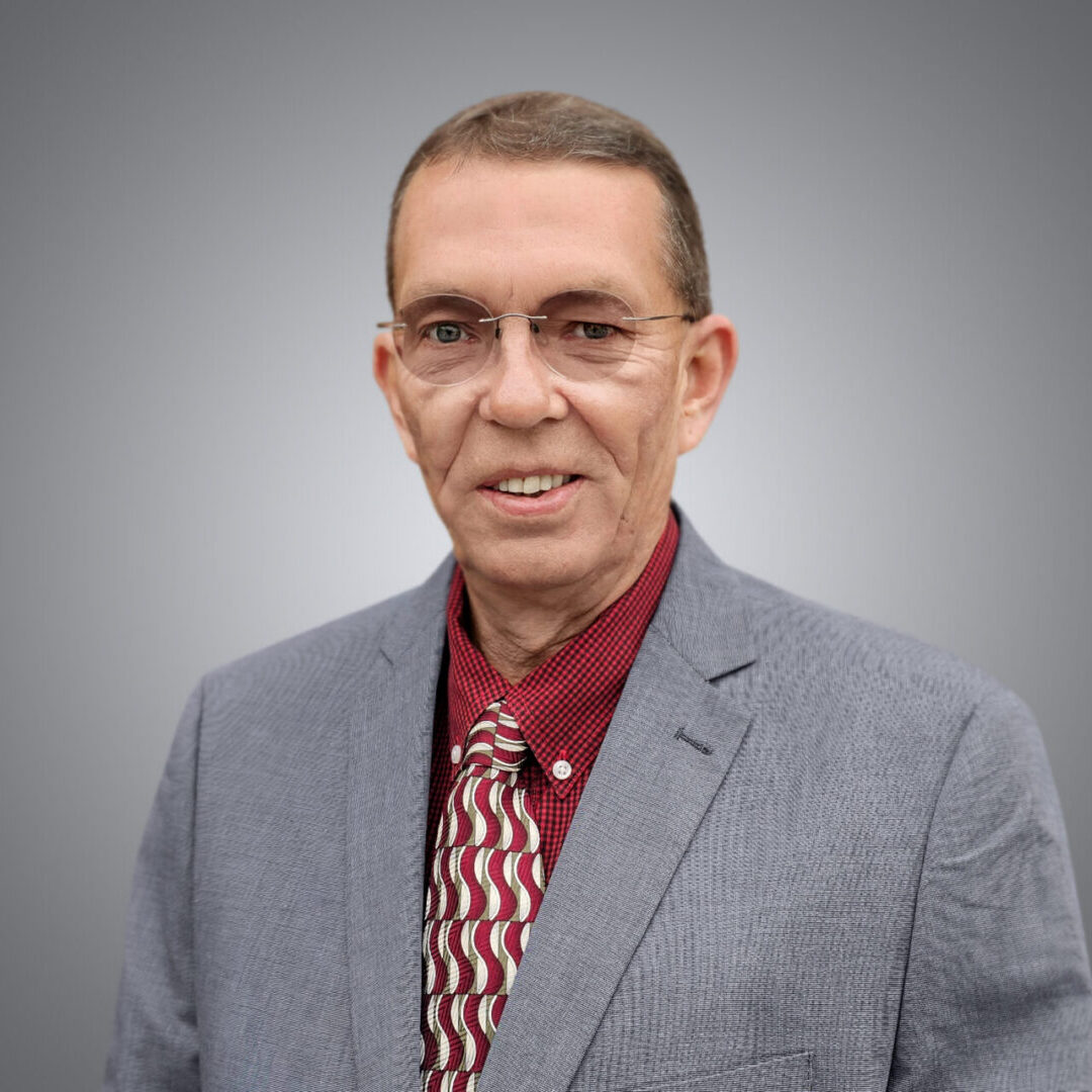 Smiling man in gray suit and patterned tie